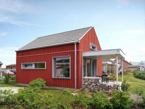 una casa roja con techo de gambrel en Schwedenrotes Ferienhaus Wismar en Zierow