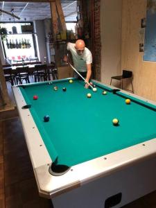 a man playing a game of pool on a pool table at Casita - Sterneferienhaus mit Garten, Sauna und Wallbox in Kirburg