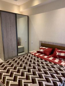 Un dormitorio con una cama grande con almohadas rojas. en APARTMENT THREE BEDROOM IN SABURTALO, en Tiflis 9 fotos más