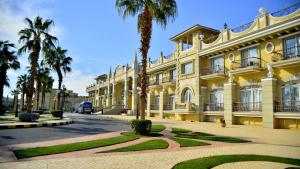ein großes gelbes Gebäude mit Palmen davor in der Unterkunft IL Mercato Hotel & Spa in Sharm El Sheikh
