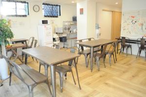 a classroom with tables and chairs and a refrigerator at 04 village Namba - Vacation STAY 02386v in Osaka