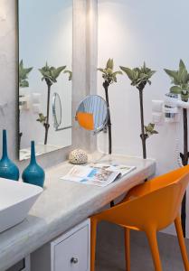 a bathroom with a counter with a sink and a mirror at Kouros Village Hotel - Adults Only in Perissa