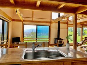 a kitchen with a sink in a room with windows at Kitaarupusu ichibō no ie - Vacation STAY 96488v in Omachi