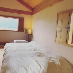 a white bed in a room with a window at Kitaarupusu ichibō no ie - Vacation STAY 96488v in Omachi