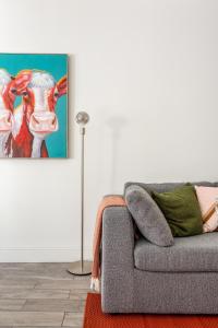 a living room with a couch and a painting of a cow at East Street Apartments, The Lanes Brighton in Brighton & Hove