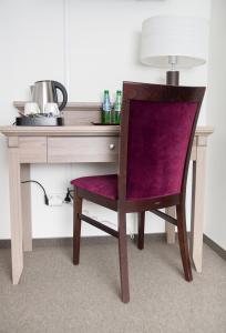 escritorio con silla púrpura y mesa con lámpara en WILla Medica, en Poznan