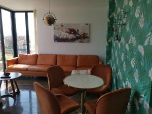 - un salon avec un canapé, une table et des chaises dans l'établissement Gonik Apartmani, à Veliko Gradište