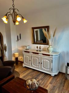 a living room with a white dresser with a mirror at Am Stephanswäldchen in Kamp-Lintfort +19 photos