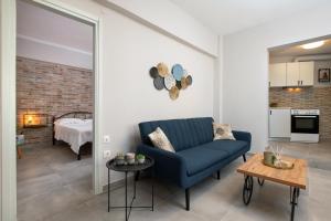 a living room with a blue couch and a bedroom at Silvia's Apartments in Corfu