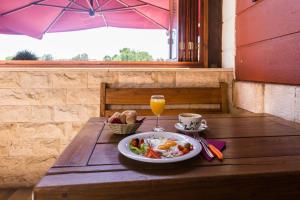 a table with a plate of food and a glass of orange juice at B&B Giardin exclusive rooms and suite in Zadar