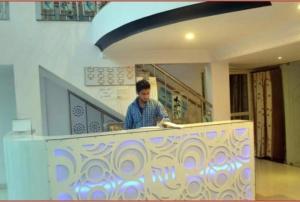a man standing behind a counter in a building at Hotel Rock View in Pachmarhī