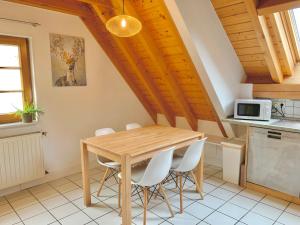 una cucina con tavolo in legno e sedie bianche di Ferienwohnung Diana a Sexau