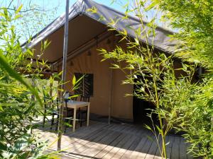 eine Veranda eines Hauses mit einer Holzterrasse in der Unterkunft Ludocamping in Lussas