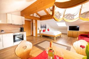 a kitchen and a living room with a table at Alphirt Ferienwohnungen in Fischen