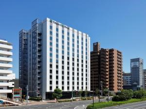 un edificio blanco alto en una calle de la ciudad con edificios en Tmark City Hotel Tokyo Omori - Vacation STAY 26381v en Tokio