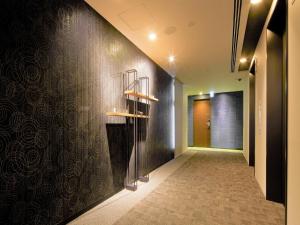 un corridoio con un muro nero e scaffali sopra di Tmark City Hotel Tokyo Omori - Vacation STAY 26381v a Tokyo