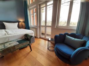 a bedroom with a bed and a couch and a chair at Hotel Villa Viktoria Luise in Blankenburg