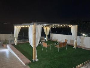 a gazebo with curtains and chairs on a lawn at night at Acquamarina in Gaeta