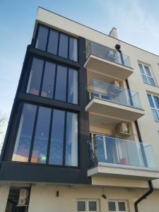 an apartment building with glass balconies at Gonik Apartmani in Veliko Gradište