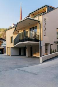 a building with a balcony on the side of it at Lebe`oetz - Das Ferienapartmenthaus im Zentrum von Oetz in Oetz