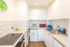 a kitchen with white cabinets and a red microwave at Chester Stays - Lovely apartment in the heart of Chester with free parking in Chester