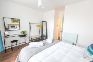een slaapkamer met een groot wit bed en een spiegel bij Chester Stays - Lovely apartment in the heart of Chester with free parking in Chester