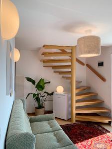 a living room with a green couch and stairs at Lakeview Guesthouse & Chalet Bled in Bled