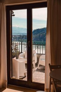 een kamer met uitzicht op het water door een glazen deur bij Lakeview Guesthouse & Chalet Bled in Bled