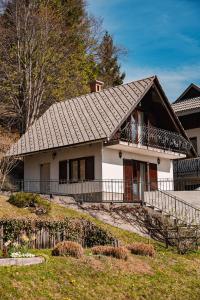 een klein wit huis met een zwart dak bij Lakeview Guesthouse & Chalet Bled in Bled