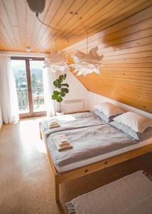 a bed in a room with a wooden wall at Lakeview Guesthouse & Chalet Bled in Bled