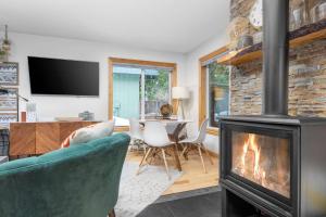 Una sala de estar con chimenea y una mesa y sillas. en Mountain Rose, en Government Camp