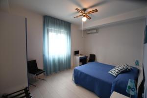 マッティナータにあるBed and breakfast Coppadicuocobbのベッドルーム1室(青いベッド1台、天井ファン付)