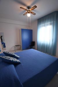 マッティナータにあるBed and breakfast Coppadicuocobbのベッドルーム1室(青いベッド1台、シーリングファン付)