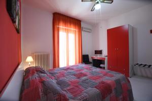マッティナータにあるBed and breakfast Coppadicuocobbのベッドルーム1室(ベッド1台、赤いキャビネット、デスク付)