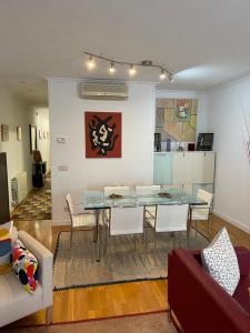 comedor y sala de estar con mesa y sillas en Channing Apartment en Barcelona