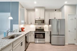 Eine Küche mit weißen Schränken und Edelstahlgeräten in der Unterkunft ZenHomes in heart of Brandon convenient location in Brandon