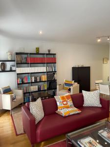 sala de estar con sofá rojo y estante para libros en Channing Apartment en Barcelona