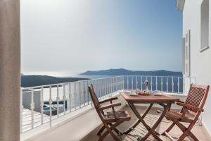 a dining room table with a balcony overlooking the ocean at Atlantis Hotel in Fira