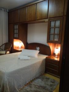 - une chambre avec un grand lit et une tête de lit en bois dans l'établissement San Pietro, à Gramado