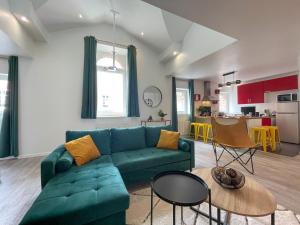 a living room with a green couch and a kitchen at Superbe appartement-Sauna-Cinéma-Parking-Gare in Amiens