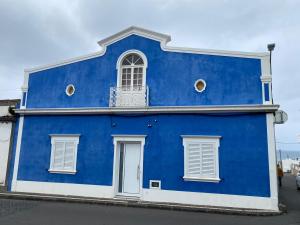 a blue building with a window and a balcony at Casa Azul in Ribeira Grande