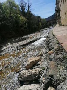 a river with rocks on the side of a road at Le Valhalla, studio au pied des thermes in Rennes-les-Bains