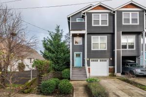 a black house with a blue door and a car at Woodstock Townhouse in Portland