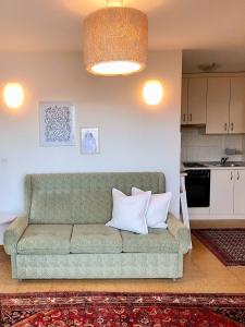 ein Wohnzimmer mit einer grünen Couch mit zwei Kissen in der Unterkunft Lakeview Guesthouse & Chalet Bled in Bled