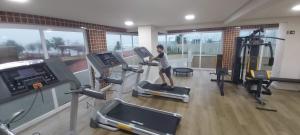 un garçon marchant sur un tapis roulant dans une salle de sport dans l'établissement APTO NOVO PÉ NA AREIA - Praia do Sonho, Itanhaém, à Itanhaém