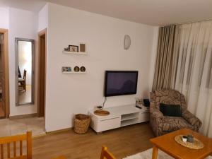 a living room with a television and a chair at Apartman Lucija Međugorje in Međugorje +2 photos