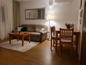 a living room with a couch and a table and chairs at Apartman Lucija Međugorje in Međugorje