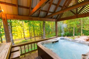 a jacuzzi tub in a cabin in the woods at Cherry Ridge Retreat Luxury Cabins 