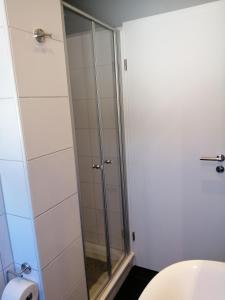 a shower with a glass door in a bathroom at Bude im Windrosenweg in Cuxhaven +26 photos