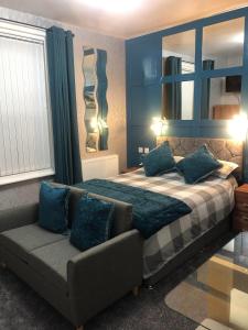 een slaapkamer met een bed en een bank bij Baxter Holiday Apartments in Blackpool